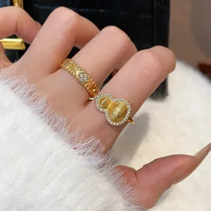 Detailed macro shot of gold-plated rings featuring intricate gourd and flower designs with zircons.