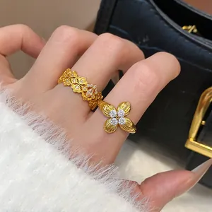 Close-up detail of elegant gold-plated flower rings with zircon stones on female hand