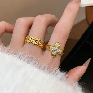 Close-up detail of gold plated flower rings with shimmering cubic zirconia stones on model hand