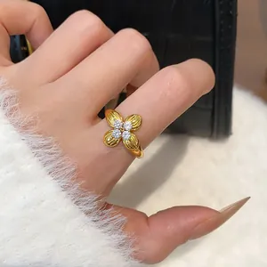 Close-up view of a gold-plated flower ring with zircon accents on a model's index finger