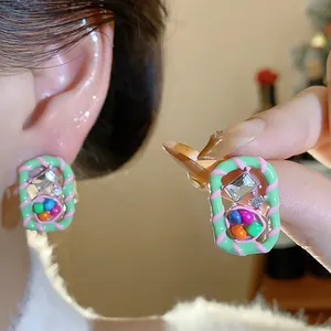 Macro view of colorful dopamine geometric stud earrings with sparkling rhinestones.