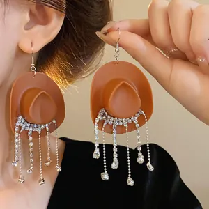 Vista dettagliata di orecchini a cappello da cowboy con frange di strass.