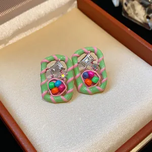 Detail shot of colorful dopamine style geometric earrings with sparkling crystals.