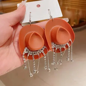 Vista dettagliata di orecchini a cappello da cowboy arancioni con nappe di strass