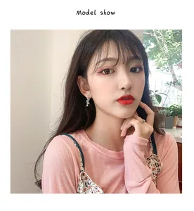 Elegant close-up of model wearing Korean style white floral tassel drop earrings