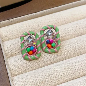 Macro view of colorful dopamine style geometric stud earrings with sparkling rhinestones