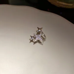 Vista detallada de un pendiente de clip plateado con estrellas de circonitas claras