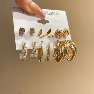 Detail view of mixed 6-pair gold earring set featuring pearls, butterflies, and hoops