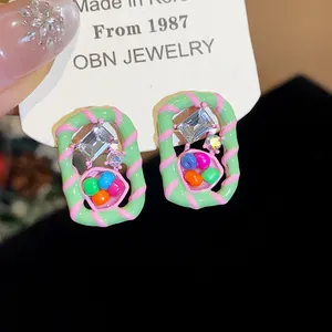 Close-up detail of vibrant dopamine style geometric stud earrings with colorful beads