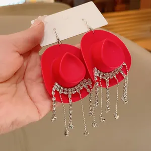 Dettaglio orecchini a forma di cappello da cowboy rosso con nappe in strass lucenti