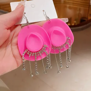 Dettaglio di orecchini a cappello da cowboy rosa con frange di strass brillanti e nappe
