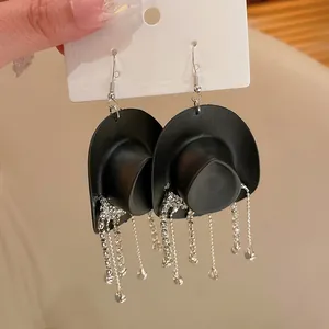 Vista dettagliata di orecchini a cappello da cowboy neri con nappe di strass brillanti