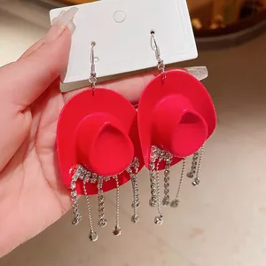 Dettaglio macro di orecchini a cappello da cowboy rossi con nappe di strass brillanti