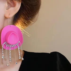 Dettaglio degli orecchini a cappello da cowboy rosa con nappe di strass brillanti