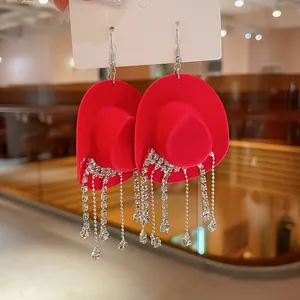 Primo piano di orecchini a forma di cappello da cowboy rosso con nappe di strass.