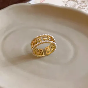 Detailed macro close-up of an elegant gold ring featuring pearls and square zirconia