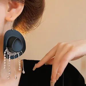 Dettaglio orecchino a cappello da cowboy nero con lunghe nappe di strass brillanti