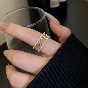 Detailed macro shot of vintage gold open ring featuring elegant pearls and square zircons