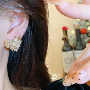 Détail en gros plan d'une boucle d'oreille cœur plaquée or 18k avec zircons sur un mannequin
