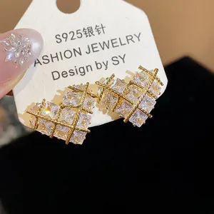 Gros plan détaillé de boucles d'oreilles cœur dorées avec pierres de zircone cubique