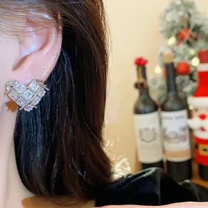 Vue détaillée d'une boucle d'oreille en zircon étincelante en forme de cœur sur une oreille