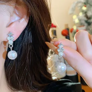 Primo piano di orecchini d'argento stile francese con cristalli scintillanti e perle.