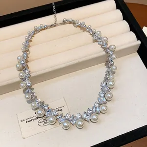 Vista macro dettagliata dell'elegante collana di perle e strass in stile francese su vassoio