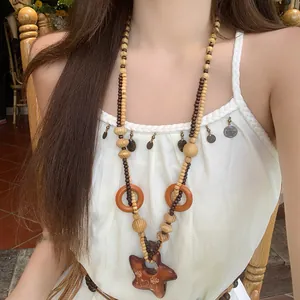 Collana bohémien di perline di legno con grande pendente a stella indossata da una modella