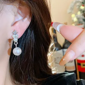 Dettaglio di un elegante orecchino francese con strass e perla su orecchio modella