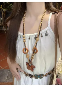 Modella che indossa una collana bohémien di perline di legno con ciondolo a stella