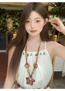 Collana bohémien con lunghe perle in legno e grande pendente a stella indossata da una modella.