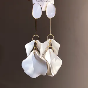 Macro detail of elegant vintage drop earrings featuring white petals and oval tops