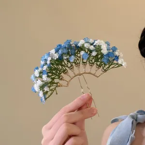Detailansicht einer blau-weißen Schleierkraut-Haargabel mit einem goldenen U-förmigen Pin.