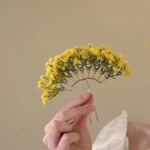 Detailansicht einer eleganten Haarnadel mit kleinen gelben Blumen im Wald-Design-Stil