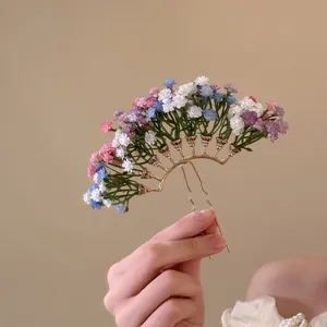 Detailansicht einer fächerförmigen Haarnadel mit bunten Schleierkrautblüten geschmückt
