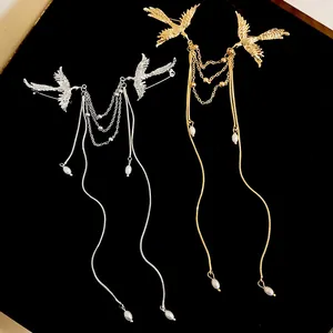 Detailed view of phoenix brooches with pearl tassels in gold and silver finishes