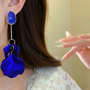 Close-up of elegant royal blue petal drop earrings with blue enamel stud on model
