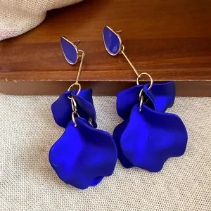 Close-up detail of elegant royal blue petal drop earrings featuring gold-tone metal accents