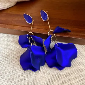 Detailed macro view of elegant Klein blue petal drop earrings with gold-toned accents