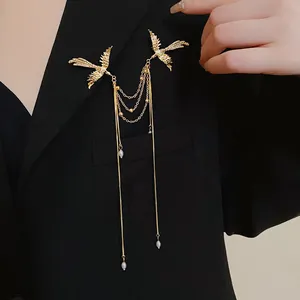 Elegant golden phoenix brooch with long pearl tassels shown pinned on black blazer.