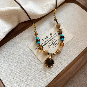 Detailed macro view of a vintage tiger eye beaded necklace on a rustic wooden tray.