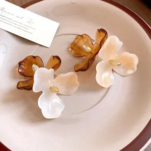 Gros plan de boucles d'oreilles fleurs en acrylique vintage ambre et crème