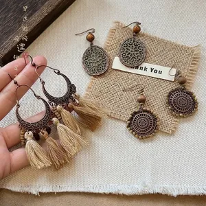Orecchini etnici in stile boho con lunghe nappe, motivi in metallo e perline