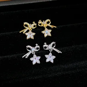 Primer plano de elegantes pendientes de lazo y estrella de circonita en oro y plata