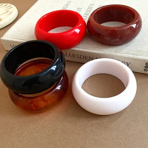 Detailed view of retro chunky resin bangles in red, white, black, and amber finishes