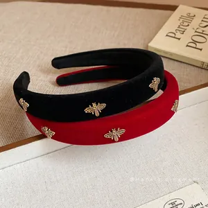 Elegant velvet headbands in black and red featuring delicate golden bee embellishments.