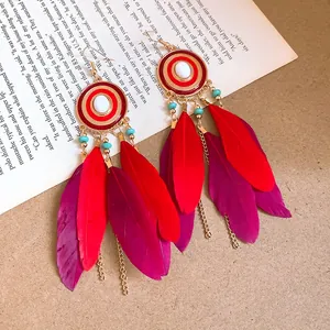 Orecchini etnici con piume rosse, dettagli dorati e accenti di perline blu per donna.