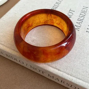 Detailed close-up view of a retro amber resin bangle with elegant marbled swirl patterns