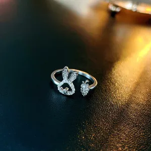 Detailed macro shot of a silver rabbit and carrot open ring featuring sparkling white zircons.