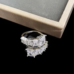 Detailed view of a silver plated open ring with geometric square cut zirconia stones.